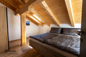 a large bed in a room with wooden ceilings at Wieserhof Sellrain in Sellrain