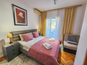 a bedroom with a bed and a chair in it at Guesthouse Elsa in Ulcinj