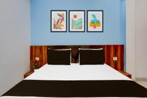 a bedroom with a large white bed with a blue ceiling at Hotel O Adinath Guest House in Bahādrābād