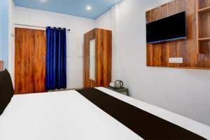 a bedroom with a bed and a flat screen tv at Hotel O Adinath Guest House in Bahādrābād