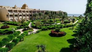 a resort with a green lawn and a large building at PLM hotel Prima Life Makadi in Hurghada