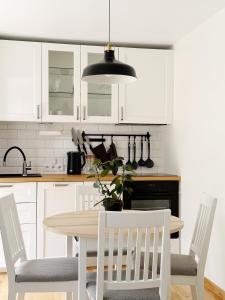 a kitchen with white cabinets and a table and chairs at Liedagas in Kolka +25 photos