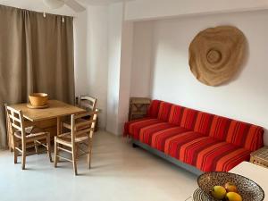 a living room with a red couch and a table at Es Pujols Vista Mare in Es Pujols