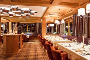 a dining room with long tables and chairs at Haus Wildschütz by Hotel Tirolerhof in Tux