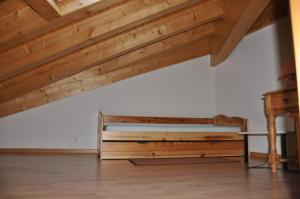 a bedroom with a wooden bed and a table at Immeuble La Foret in Vex