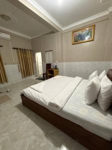 a bedroom with a large white bed and a bathroom at Koh Rong Homestay in Kaôh Rŭng (3) +13 photos