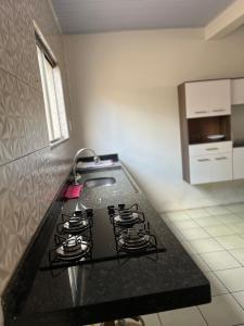 a kitchen with a black counter top with a stove at Casa da folha 12 in Marabá +7 photos