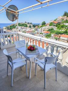 a table and chairs with a bowl of fruit on a balcony at Guesthouse Elsa in Ulcinj +41 photos