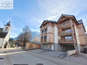 a large wooden building with a church next to a street at Mountain Suite A10 - by FiS in Tauplitz