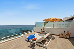 a deck with a table and an umbrella and the ocean at Callao Beach 6 in Arrieta
