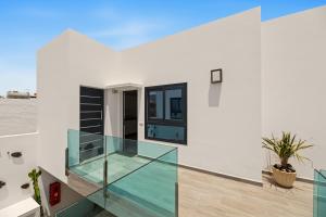 a glass staircase in a white house with a window at Callao Beach 6 in Arrieta