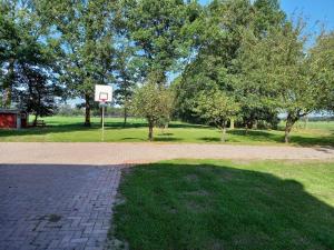 a basketball hoop in a park with trees at Ferienhaus Dat Landhuus 95158 in Rhauderfehn