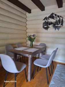 a dining room table with chairs and a vase of flowers at Тихий світанок in Synevyrsʼka Polyana +34 photos