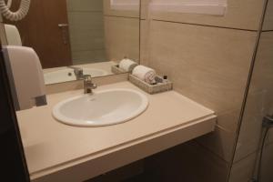 a bathroom with a sink and a mirror at Hotel Rajhans Regent in Bhopal