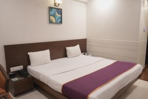 a bedroom with a large bed in a room at Hotel Rajhans Regent in Bhopal