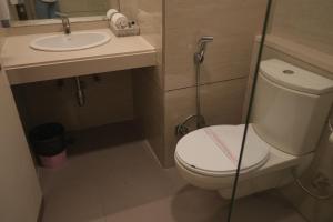 a small bathroom with a toilet and a sink at Hotel Rajhans Regent in Bhopal