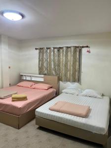 two beds sitting next to each other in a bedroom at Sky&Sea Guesthouse Cha am TK in Cha Am