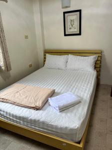 a bed with two towels on top of it at Sky&Sea Guesthouse Cha am TK in Cha Am