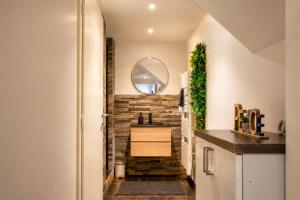 a bathroom with a sink and a brick wall at Beau gîte avec jacuzzi in Barr