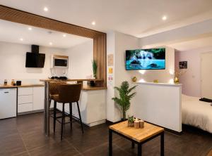 a room with a bed and a kitchen with a table at Beau gîte avec jacuzzi in Barr