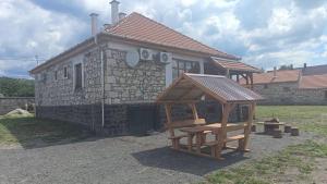 a small stone house with a wooden play structure at WINE NOT Tállya in Tállya