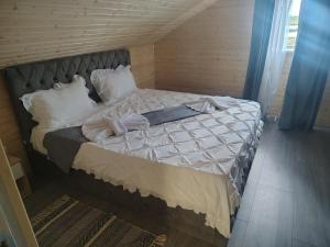 a bed with white sheets and pillows in a room at Casa Theopa in Corbu