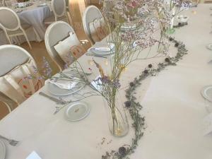 a white table with flowers in a vase on it at SNÖ Pazo de Adrán in Milladoiro