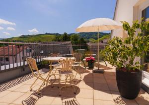 eine Terrasse mit Tisch, Stühlen und Sonnenschirm in der Unterkunft Hotel Ritter Durbach in Durbach