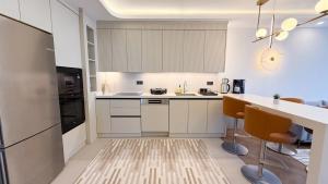 a kitchen with white cabinets and a counter and chairs at Hiper Suites Residance in Antalya