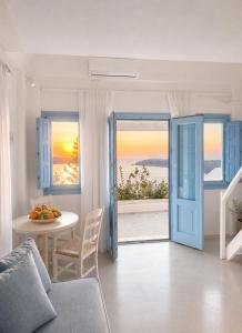 a living room with a blue door and a table at Santorini Theasis Suites in Imerovigli