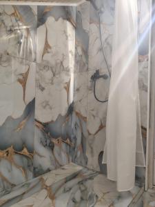 a bathroom with a shower with a marble wall at Casa Theopa in Corbu +24 photos