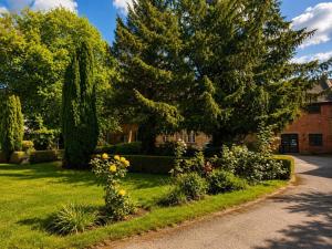 a house with a garden with flowers and trees at Primrose Manor in Risley