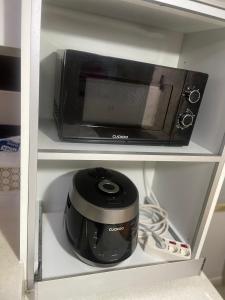 a microwave sitting on a shelf in a kitchen at 행운외국인여성전용게스트하우스 in Pup'yŏng-yŏk
