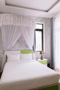 a bedroom with a large white bed with a canopy at Hoanglee Villa in Da Thanh +25 photos