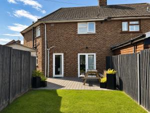 a house with a fence and a picnic table in the yard at Contractor Accommodation 4 Bedroom House Sleeps 7 Free Van Parking Near Avonmouth Docks in Avonmouth +34 photos