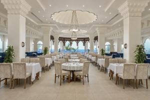 a dining room with tables and chairs and a chandelier at Continental Plaza Beach Resort in Sharm El Sheikh