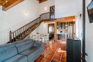 a living room with a couch and a staircase at La Dehesa de Santa Ursula Completo in Espeja de San Marcelino
