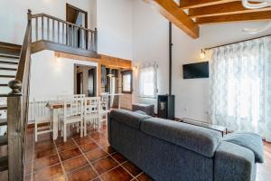 a living room with a couch and a dining room at La Dehesa de Santa Ursula Completo in Espeja de San Marcelino