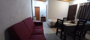a living room with a couch and a table and a bed at Departamento familiar in General Roca