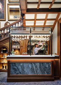 a man standing behind a bar in a restaurant at Chilston Park Hotel in Maidstone