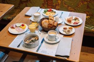 a table with breakfast foods and drinks on it at HENRI Hotel Garmisch-Partenkirchen in Garmisch-Partenkirchen