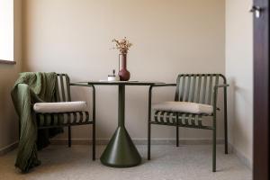 a table and two chairs with a vase on it at Fančita Rooms B&B in Vrsar
