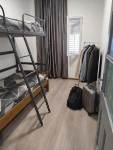 a dorm room with a bunk bed and a ladder at Sanrise Hostel in Baošići