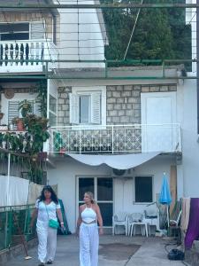 two women walking in front of a building at Sanrise Hostel in Baošići