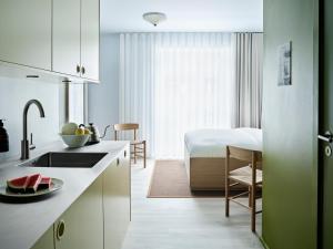 a kitchen with a sink and a bed in a room at Folk Copenhagen in Copenhagen