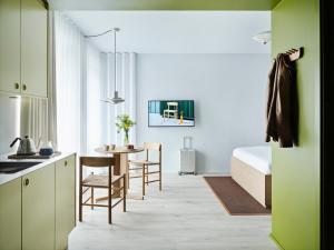 a kitchen and a bedroom with a bed and a table at Folk Copenhagen in Copenhagen
