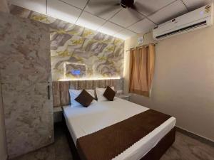 a bedroom with a bed with a painting on the wall at Hotel Dreamland in Hisār +25 photos