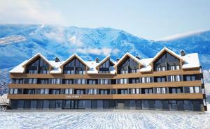 een groot gebouw met sneeuw bedekte bergen op de achtergrond bij New Gudauri Studio 222 in Goedaoeri