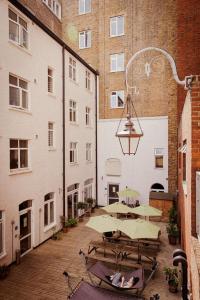 a courtyard with tables and umbrellas in a building at Wombat's City Hostel London in London