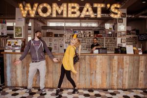 a man and a woman standing in front of a counter at Wombat's City Hostel London in London